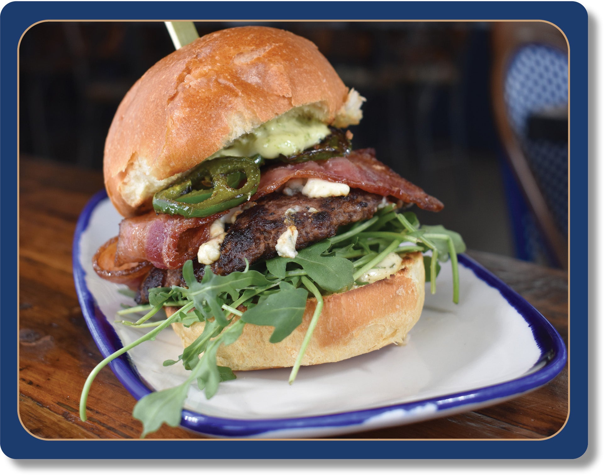 Emily's Blazin Blue Burger: 4oz House Ground Oregon Natural 100% Grass Fed Beef Patty, Jalapenos, Blue Cheese, Smoked Bacon, Arugula, Herb Aioli, Toasted Big Ed’s Potato Bun